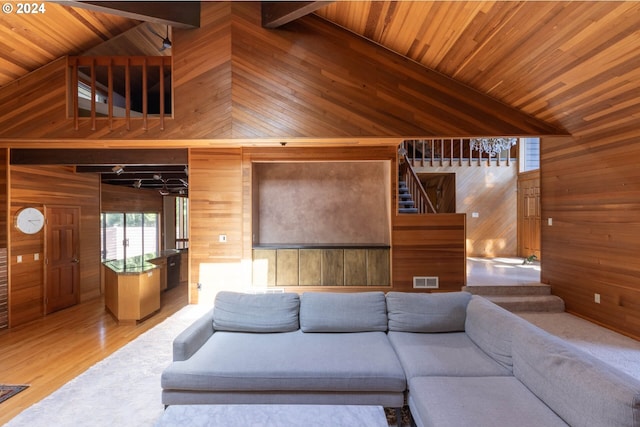 unfurnished living room featuring beamed ceiling, wooden ceiling, and wooden walls