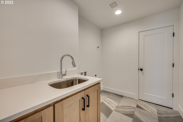 interior space with cabinets, hookup for a washing machine, and sink