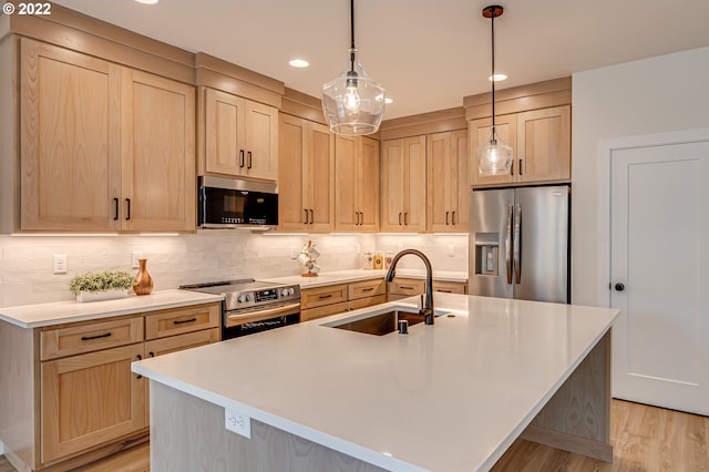 kitchen with light brown cabinetry, a kitchen island with sink, sink, and stainless steel appliances