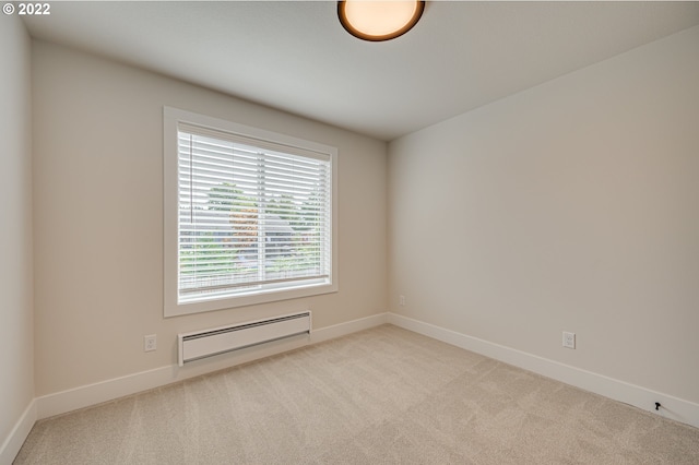 unfurnished room featuring light colored carpet and a baseboard radiator