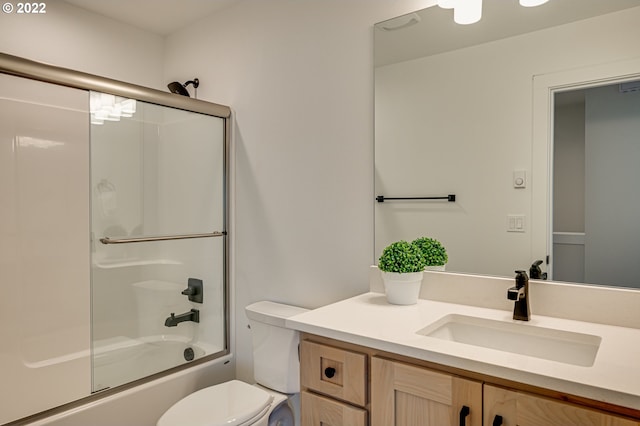 full bathroom featuring shower / bath combination with glass door, toilet, and vanity