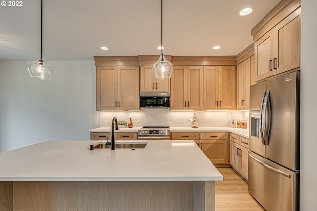 kitchen with appliances with stainless steel finishes, hanging light fixtures, light hardwood / wood-style floors, and light brown cabinetry