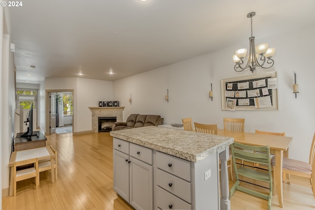 kitchen featuring a notable chandelier, a center island, hanging light fixtures, and light hardwood / wood-style floors