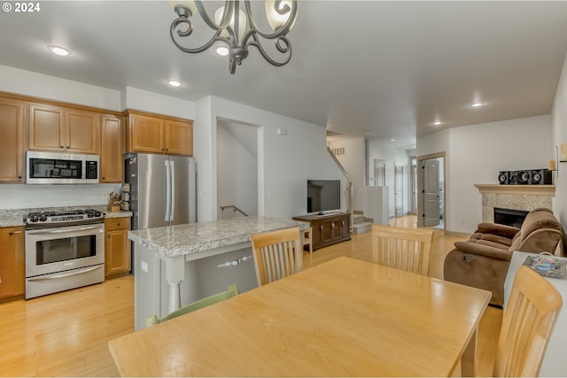 dining area with an inviting chandelier and light hardwood / wood-style floors