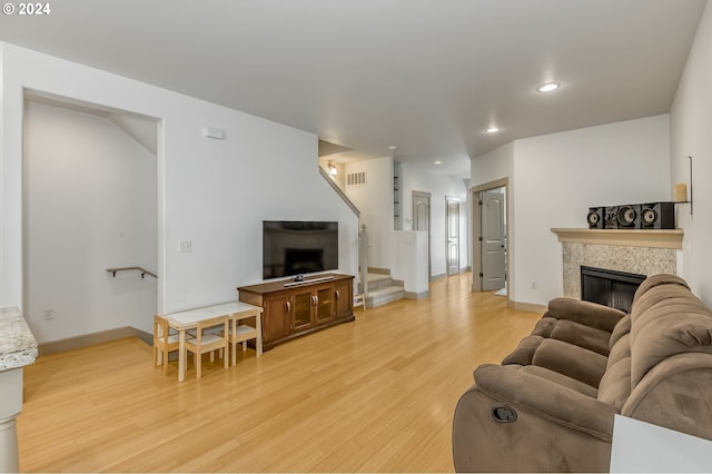 living room with a fireplace and light wood-type flooring