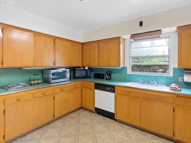 kitchen with white dishwasher, sink, and tasteful backsplash