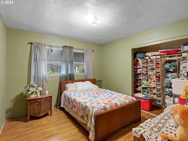 bedroom with a textured ceiling and light hardwood / wood-style floors