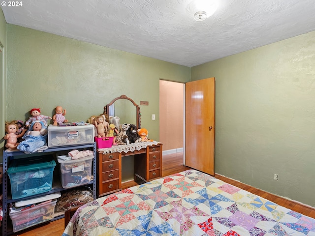 bedroom with hardwood / wood-style floors and a textured ceiling