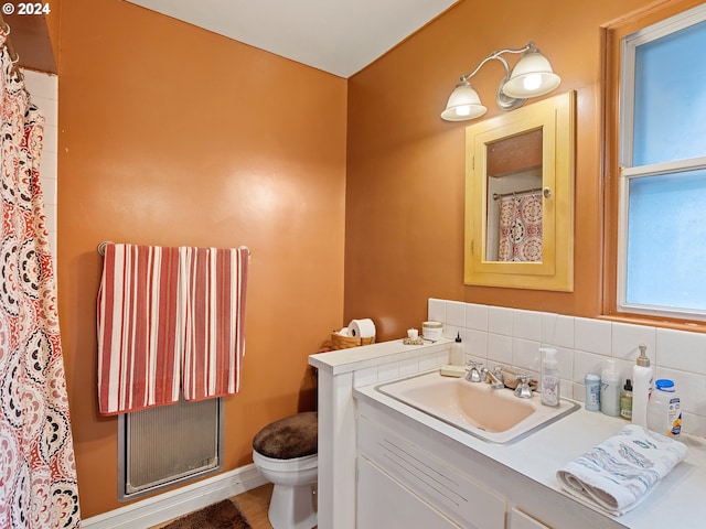 bathroom with a shower with curtain, vanity, toilet, and tasteful backsplash