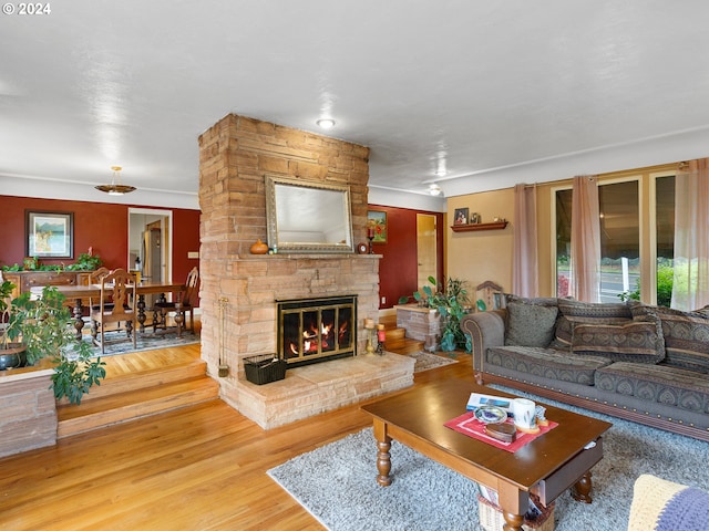 living room featuring hardwood / wood-style flooring and a stone fireplace