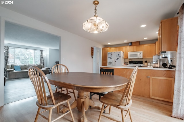 dining area with a chandelier and light hardwood / wood-style floors