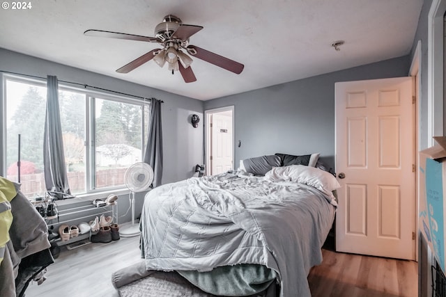 bedroom with ceiling fan, lofted ceiling, and wood-type flooring