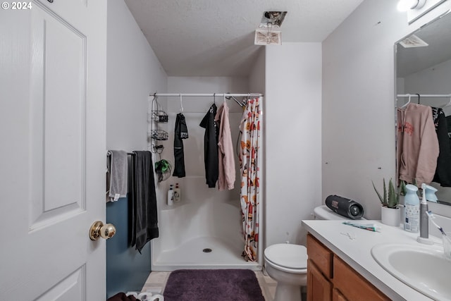 bathroom featuring toilet, vanity, a shower with shower curtain, and a textured ceiling