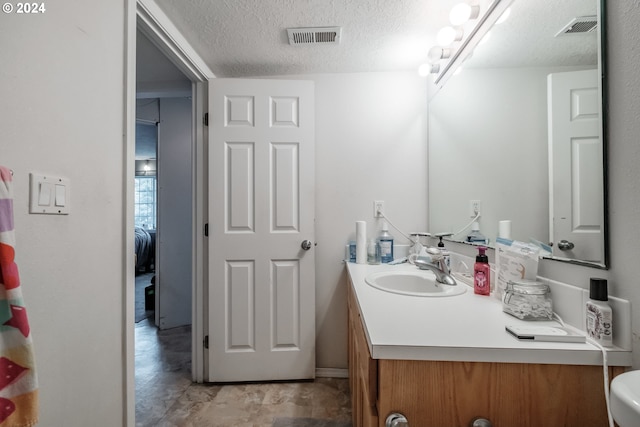 bathroom with vanity and a textured ceiling