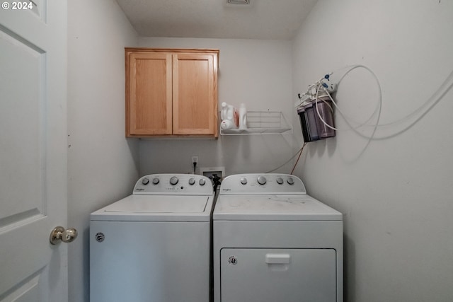 laundry area featuring cabinets and washer and clothes dryer