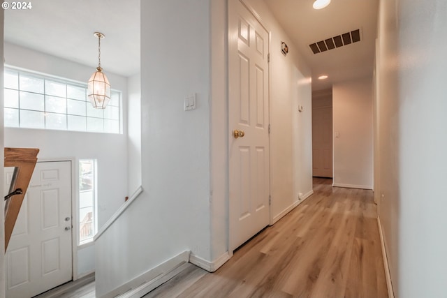 foyer with light wood-type flooring and a chandelier