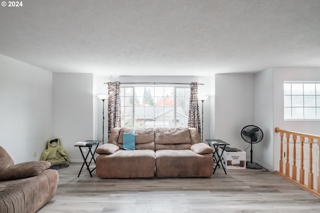 living room with light wood-type flooring and a textured ceiling