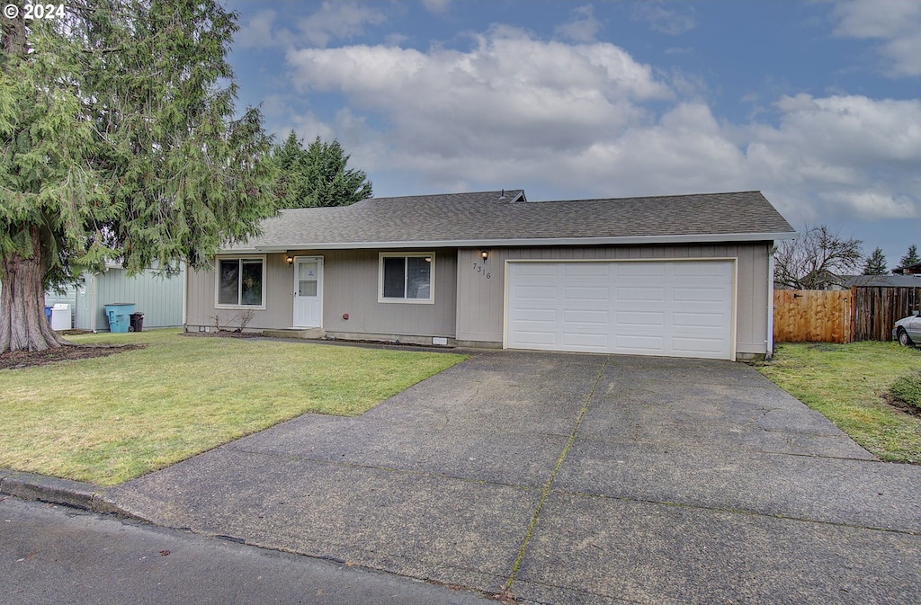 single story home with a garage and a front lawn