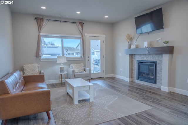 living area with baseboards, wood finished floors, and recessed lighting