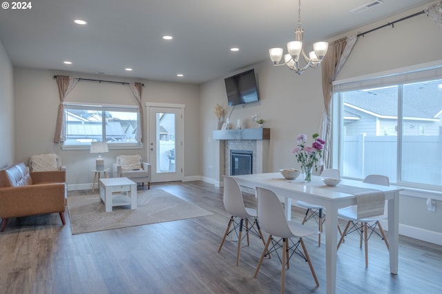 dining room featuring recessed lighting, visible vents, a glass covered fireplace, wood finished floors, and baseboards