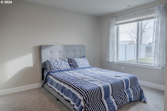 bedroom with carpet floors, visible vents, and baseboards