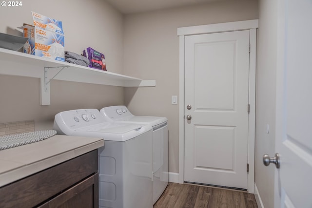 washroom featuring laundry area, independent washer and dryer, wood finished floors, and baseboards