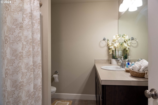 full bath with toilet, a shower with shower curtain, vanity, and baseboards