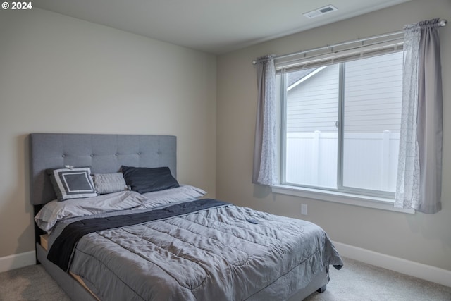 carpeted bedroom with visible vents and baseboards