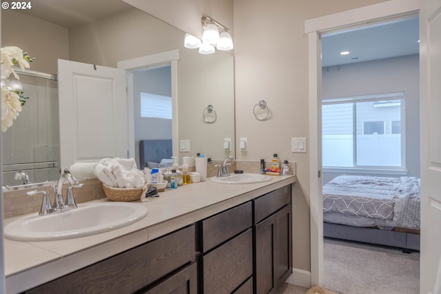 full bath featuring connected bathroom, a sink, and double vanity