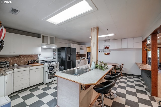 kitchen featuring double oven range, sink, black refrigerator with ice dispenser, and light tile patterned floors