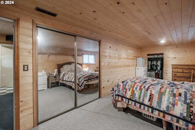 carpeted bedroom with a closet, wood walls, and wood ceiling