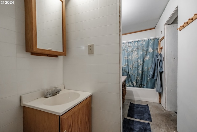 bathroom featuring concrete floors, tile walls, shower / bathtub combination with curtain, and vanity