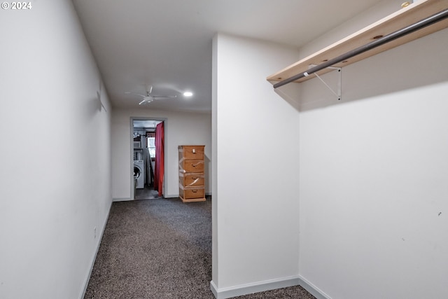 spacious closet with ceiling fan and dark carpet