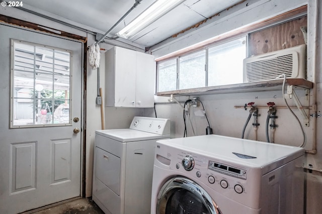 clothes washing area featuring cabinets and washing machine and dryer