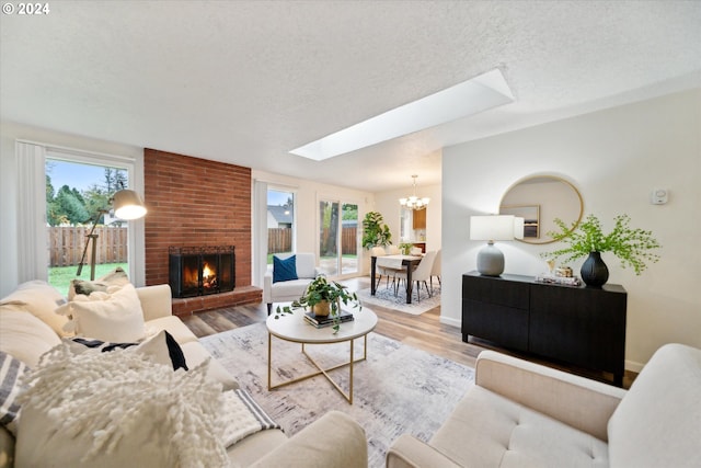 living room with a skylight, a textured ceiling, light wood-type flooring, and plenty of natural light