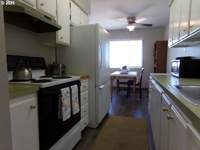 950 Evergreen Rd Unit 310, Woodburn, OR 97071 - kitchen with electric range oven, under cabinet range hood, ceiling fan, white cabinets, and dark wood finished floors