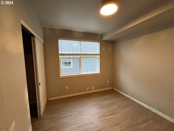 unfurnished bedroom featuring a closet and wood-type flooring