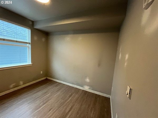 empty room with dark hardwood / wood-style flooring