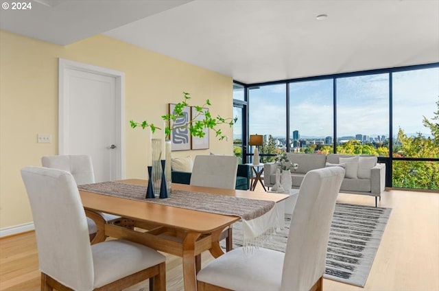 2442 NW Westover Rd Unit 3-202, Portland, OR 97210 - dining space featuring wood finished floors, floor to ceiling windows, a city view, and baseboards