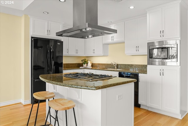 kitchen with island exhaust hood, a center island, white cabinetry, and black appliances