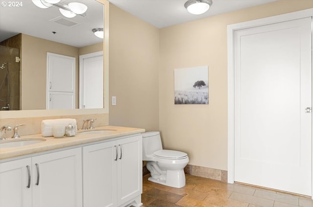 2442 NW Westover Rd Unit 3-202, Portland, OR 97210 - bathroom featuring a tile shower, toilet, double vanity, and baseboards