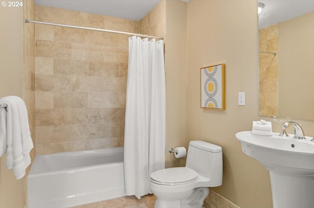 full bathroom featuring tile patterned floors, sink, shower / tub combo with curtain, and toilet