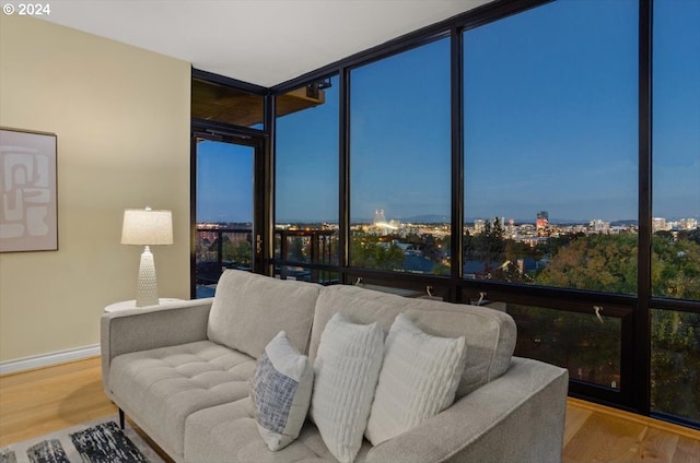 2442 NW Westover Rd Unit 3-202, Portland, OR 97210 - living area with wood finished floors, baseboards, a city view, and floor to ceiling windows