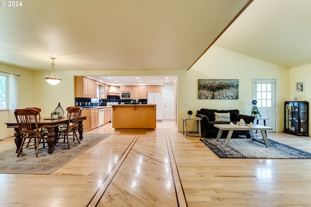 dining area with a wealth of natural light, light hardwood / wood-style flooring, and high vaulted ceiling