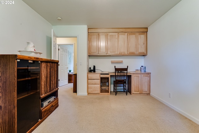 carpeted office space featuring built in desk