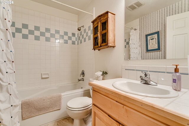 full bathroom with vanity, backsplash, toilet, and shower / bath combo with shower curtain