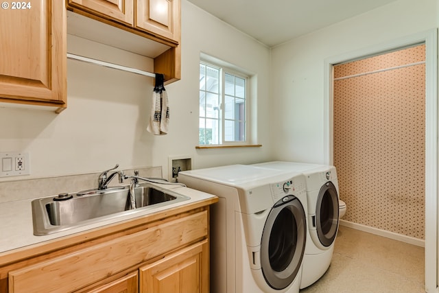 washroom with independent washer and dryer, sink, and cabinets