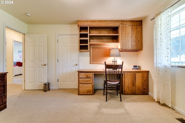 carpeted office space with built in desk