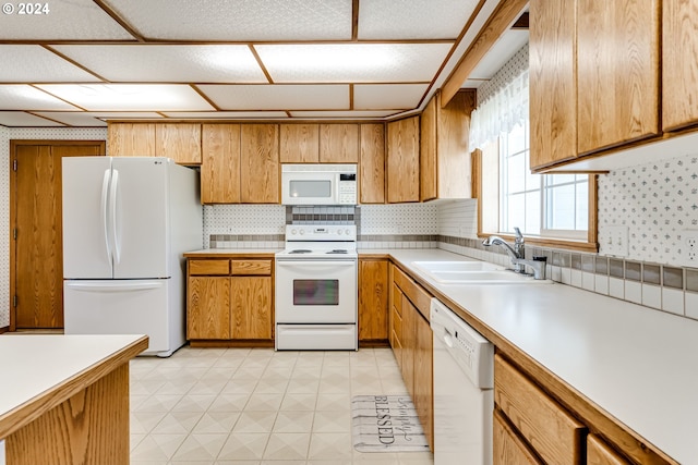 kitchen with tasteful backsplash, sink, and white appliances