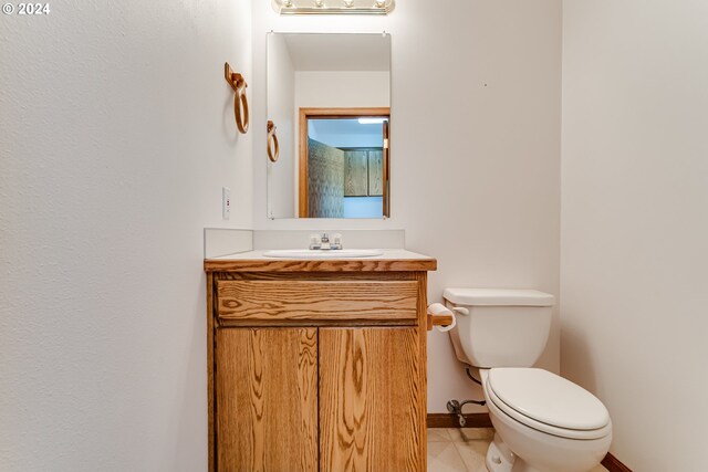 bathroom featuring vanity, tile patterned flooring, and toilet